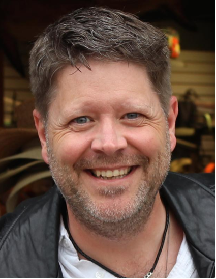 Pastor David smiling, wearing a black jacket over a white shirt