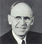 Rev. Milton Opsahl, the first pastor called by the church, smiling in glasses and a suit